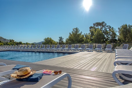 Una piscina al aire libre de temporada, sillones reclinables de piscina
