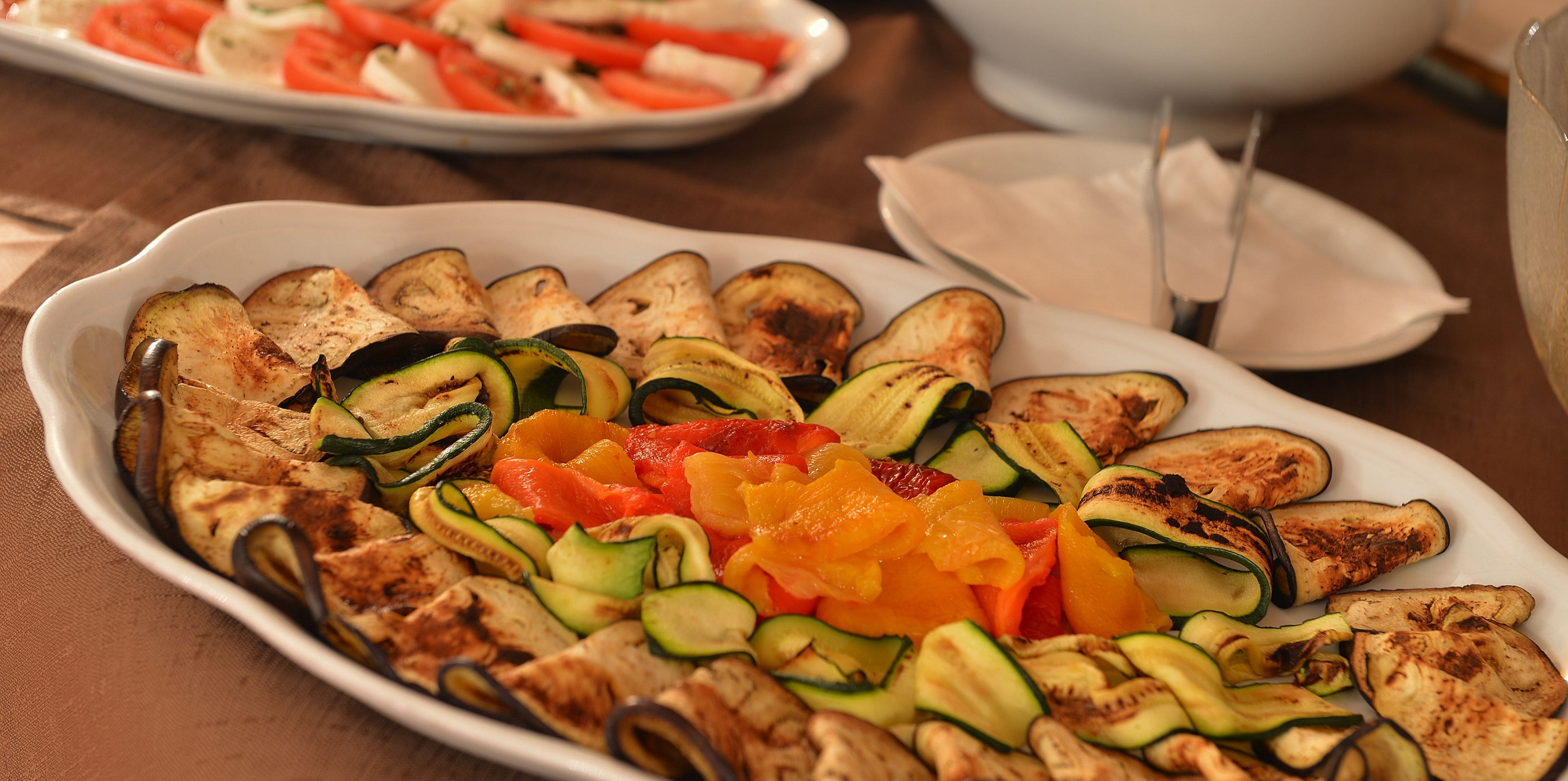 Une assiette de légumes grillés, notamment des courgettes, des aubergines et des poivrons.