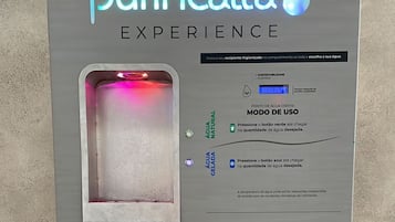 Uma estação de purificação de água com instruções de uso, um número de contato e um logotipo.