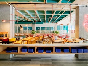 A buffet area with various food items and a seating area with red and white striped benches. - ibis budget Sao Paulo Paulista (São Paulo)