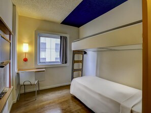 Une chambre avec un lit superposé, un bureau, une chaise et une fenêtre.