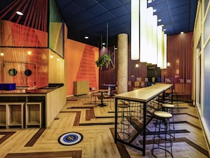 Un interior moderno con una barra larga, asientos y un suelo con diseño.