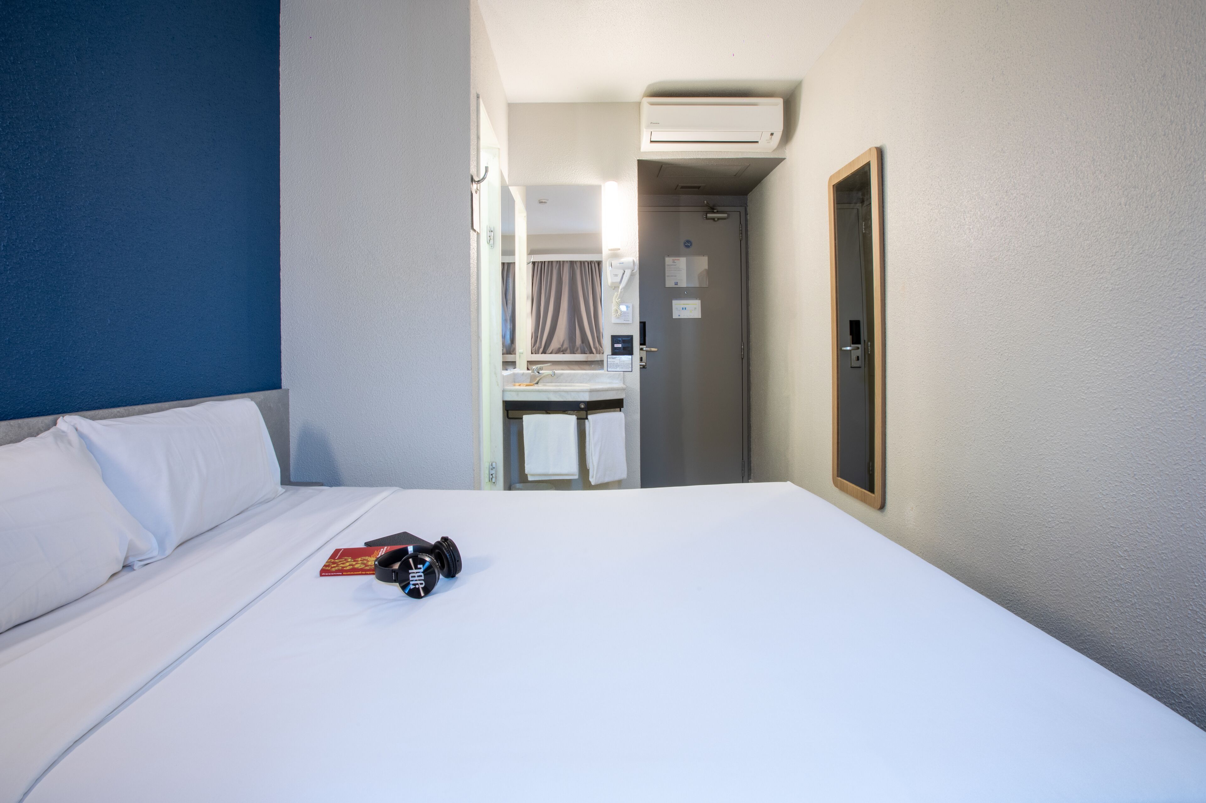 Une chambre d’hôtel équipée d’un lit, d’un bureau et d’un appareil de climatisation.