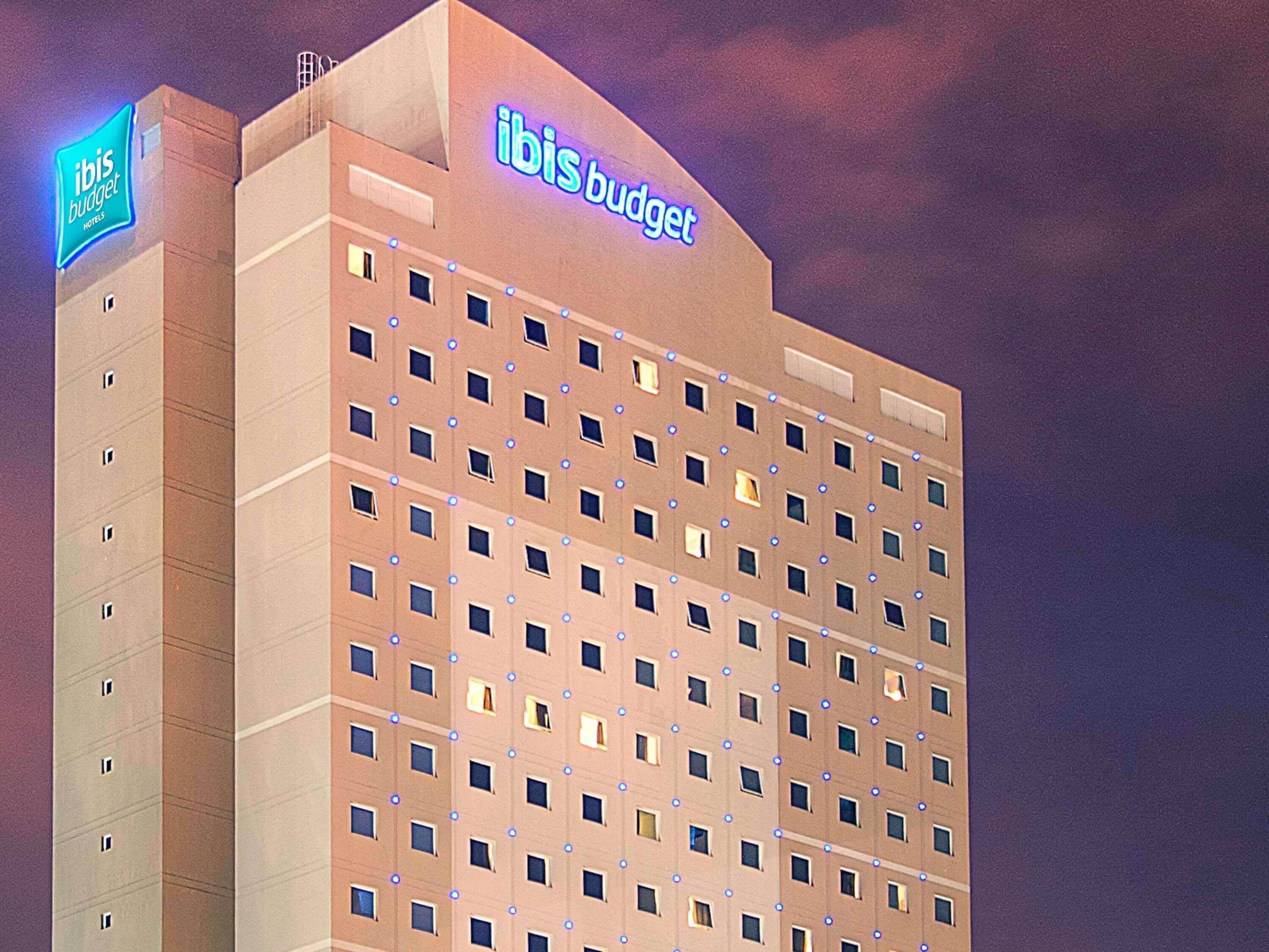 Un edificio de gran altura con un letrero que dice 'ibis budget hotels'.