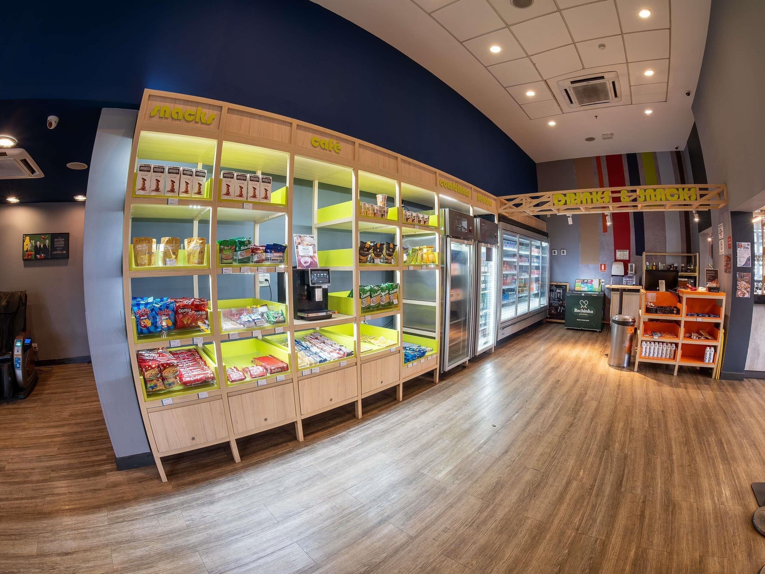 En väl upplyst kiosk som säljer snacks och diverse förpackade varor, samt har en kaffemaskin.