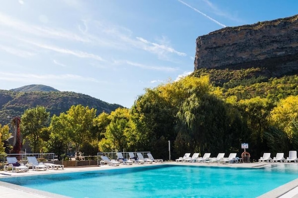 Una piscina al aire libre, sillones reclinables de piscina