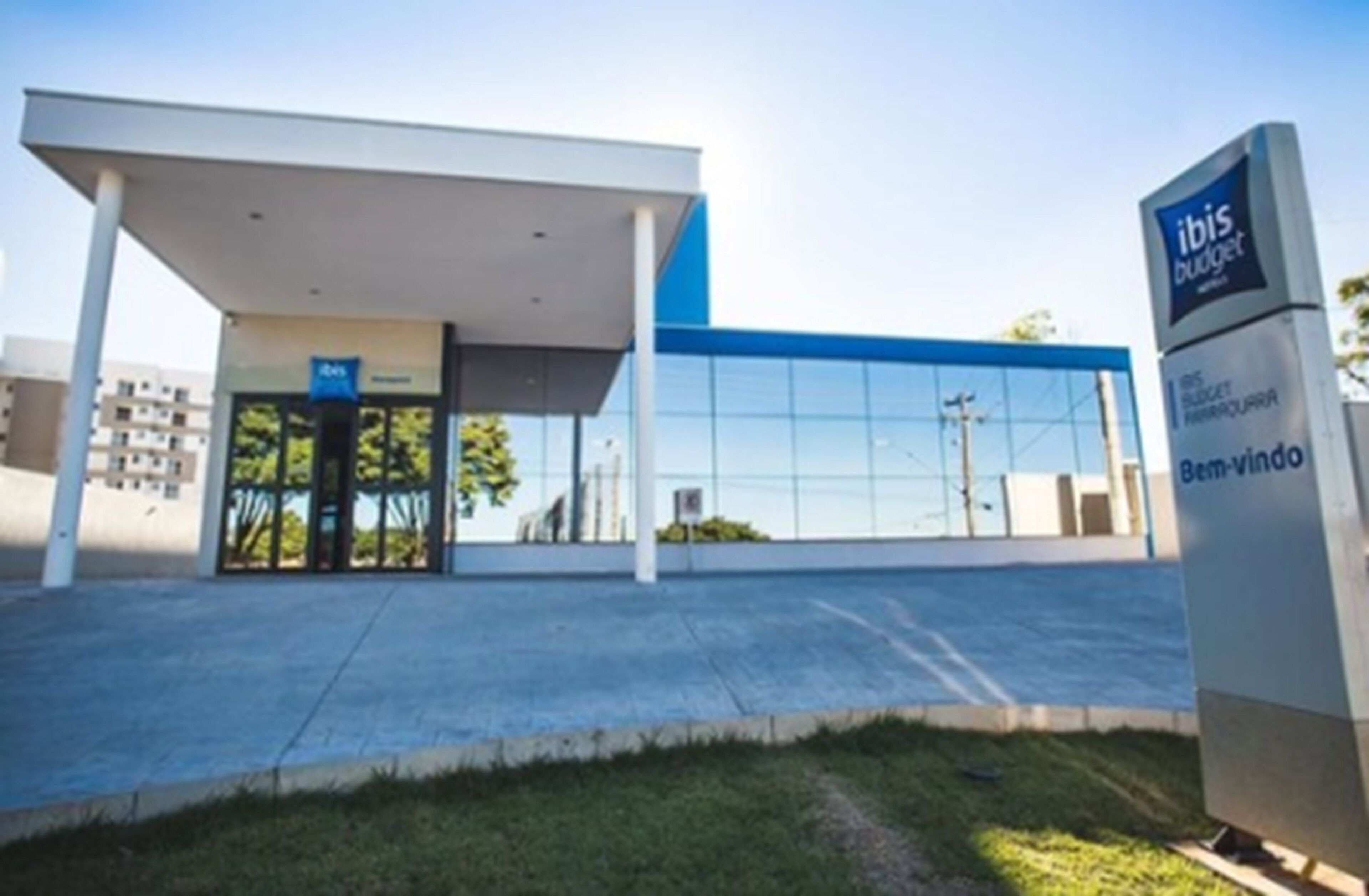 A modern building with a blue and white color scheme, featuring a sign that reads "ibis budget."