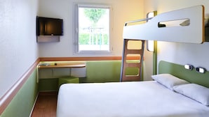 Une chambre avec un lit superposé, un bureau et une télévision.