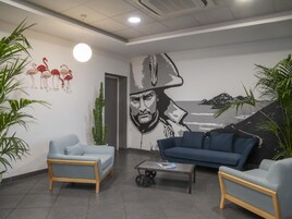 Un vestíbulo moderno con dos sofás, una mesa de centro y un mural en la pared.