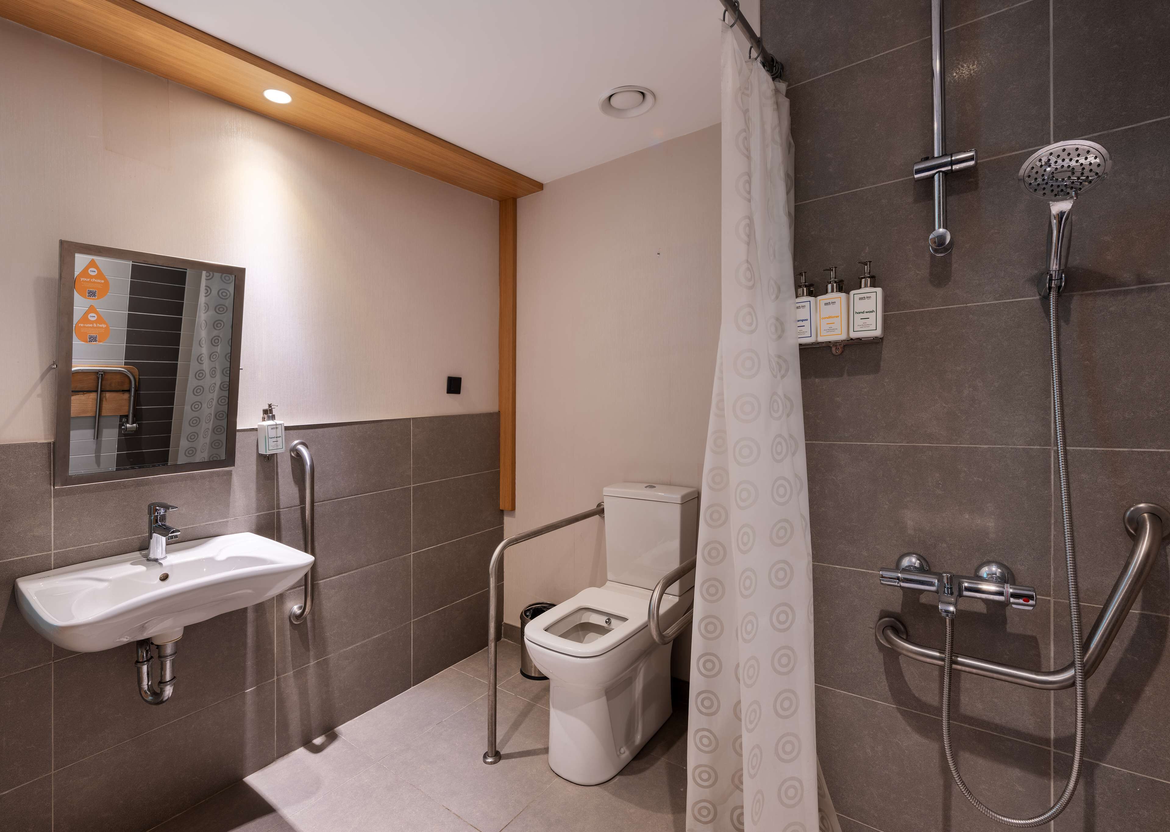 A modern bathroom with a shower, toilet, and sink.