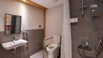A modern bathroom with a shower, toilet, and sink.