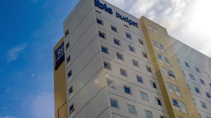 Un edificio de varios pisos con el letrero "ibis budget", indicando que es un hotel económico.