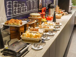 Montaje de bufé con diversos alimentos y utensilios para servir.