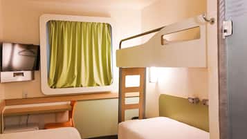 A hotel room with a bunk bed, a desk with a chair, a television, and a window with curtains.