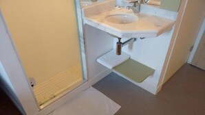 A bathroom with a white sink, a mirror, and a shower area. - ibis budget Sertaozinho (Sertaozinho)