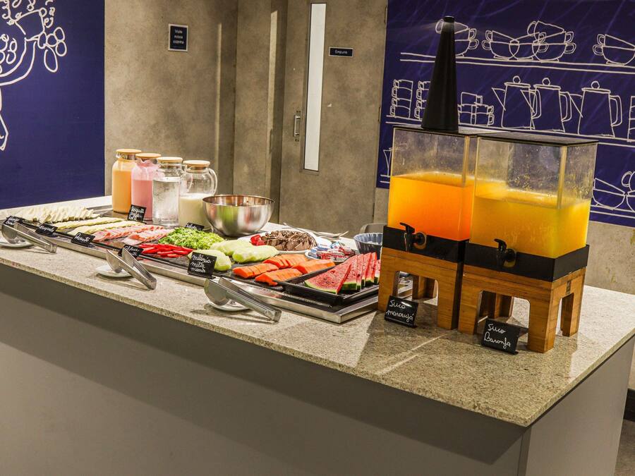 A buffet with various food items and a juice dispenser.