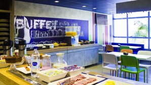 Zona de buffet amb diferents plats i begudes, un espai de cafè i una zona de seients amb taules i cadires.