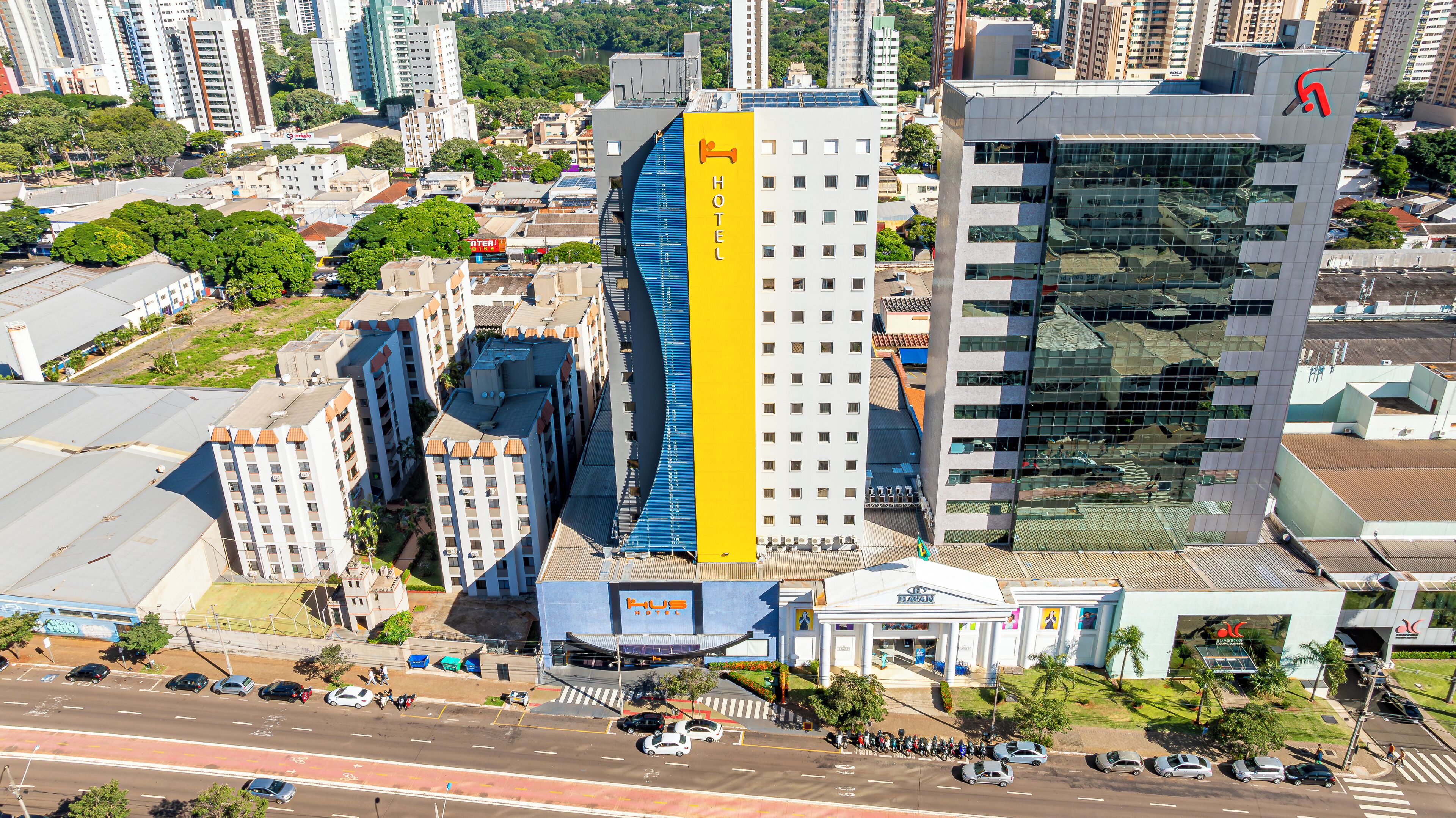 A hotel with a prominent yellow vertical stripe, multiple floors, and a modern glass facade.