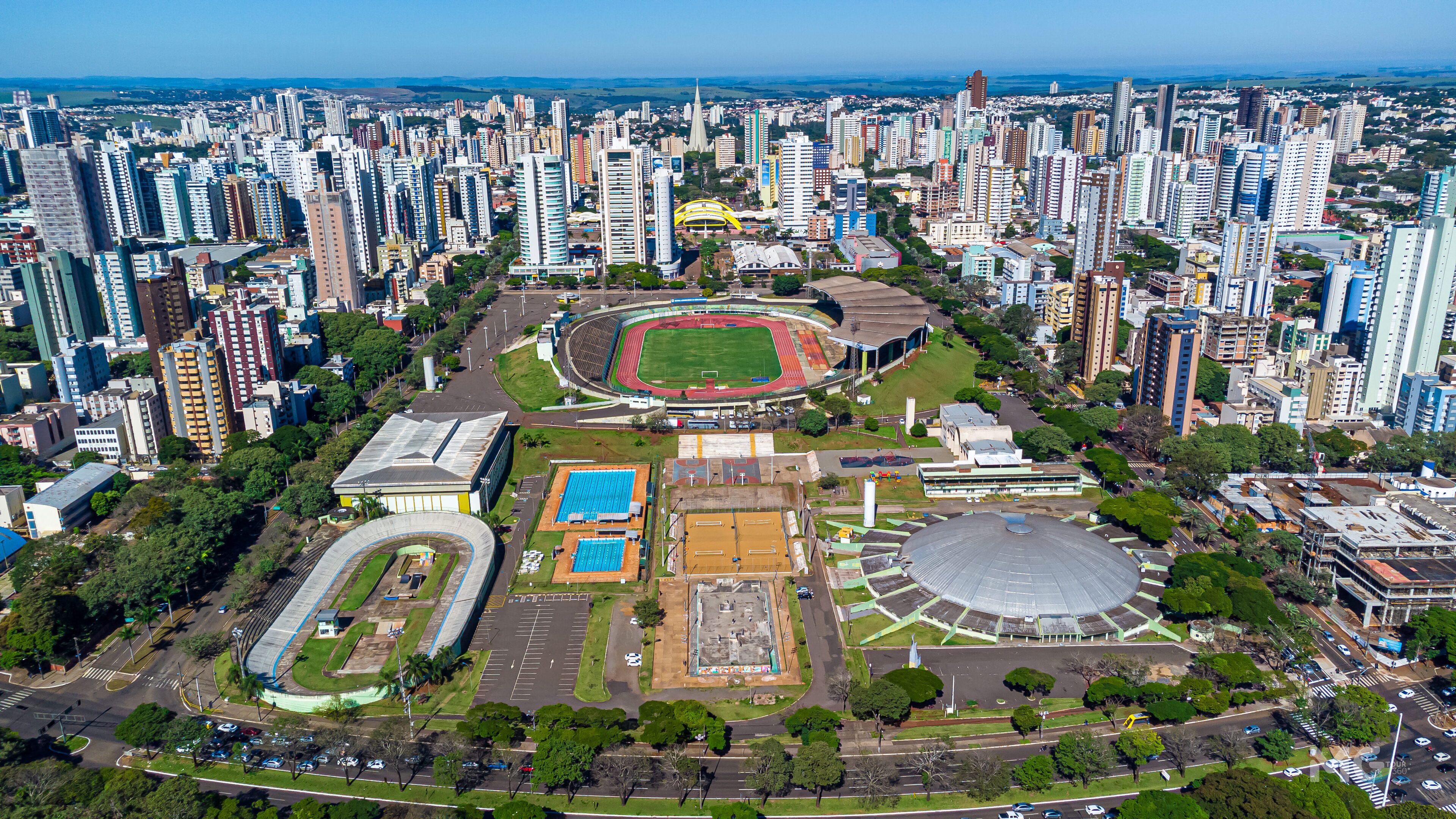 An aerial view of a city with a large stadium surrounded by high-rise buildings.