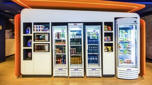 A row of vending machines with various beverages and snacks.