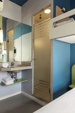 A bathroom with a sink, mirror, and shower. - ibis budget BH Afonso Pena Savassi (Belo Horizonte)