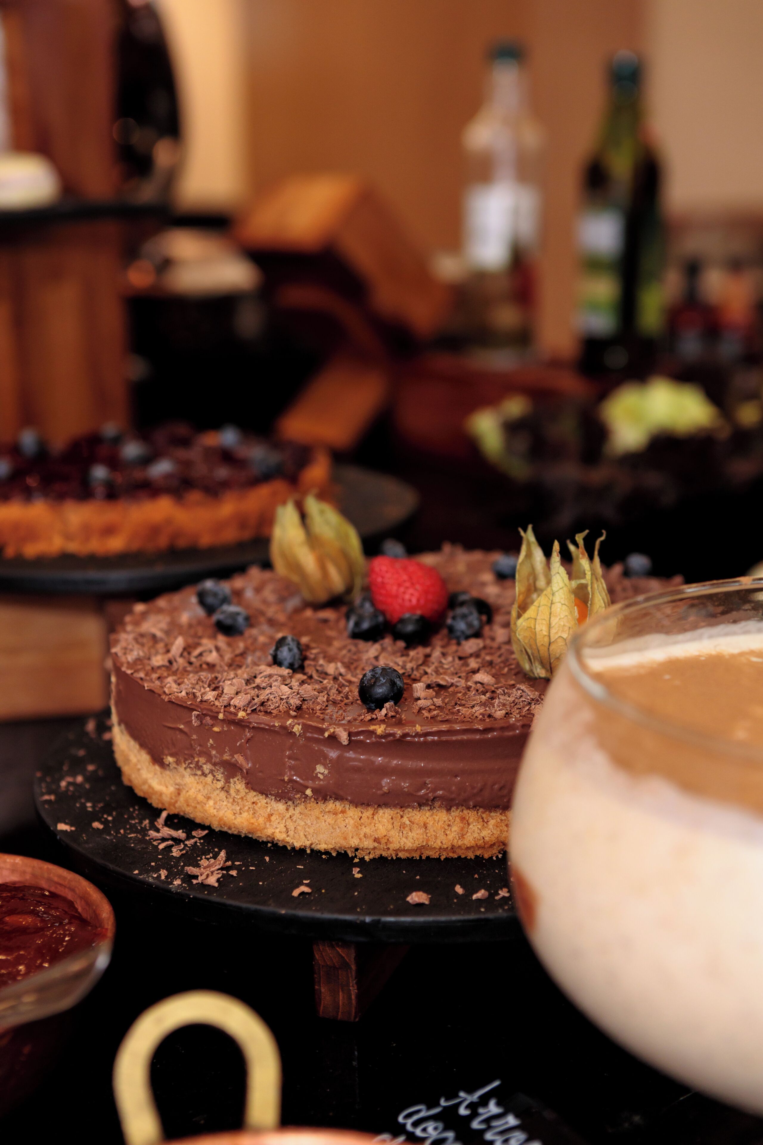 Een dessertbuffet met verschillende taarten en een grote schaal desserts.
