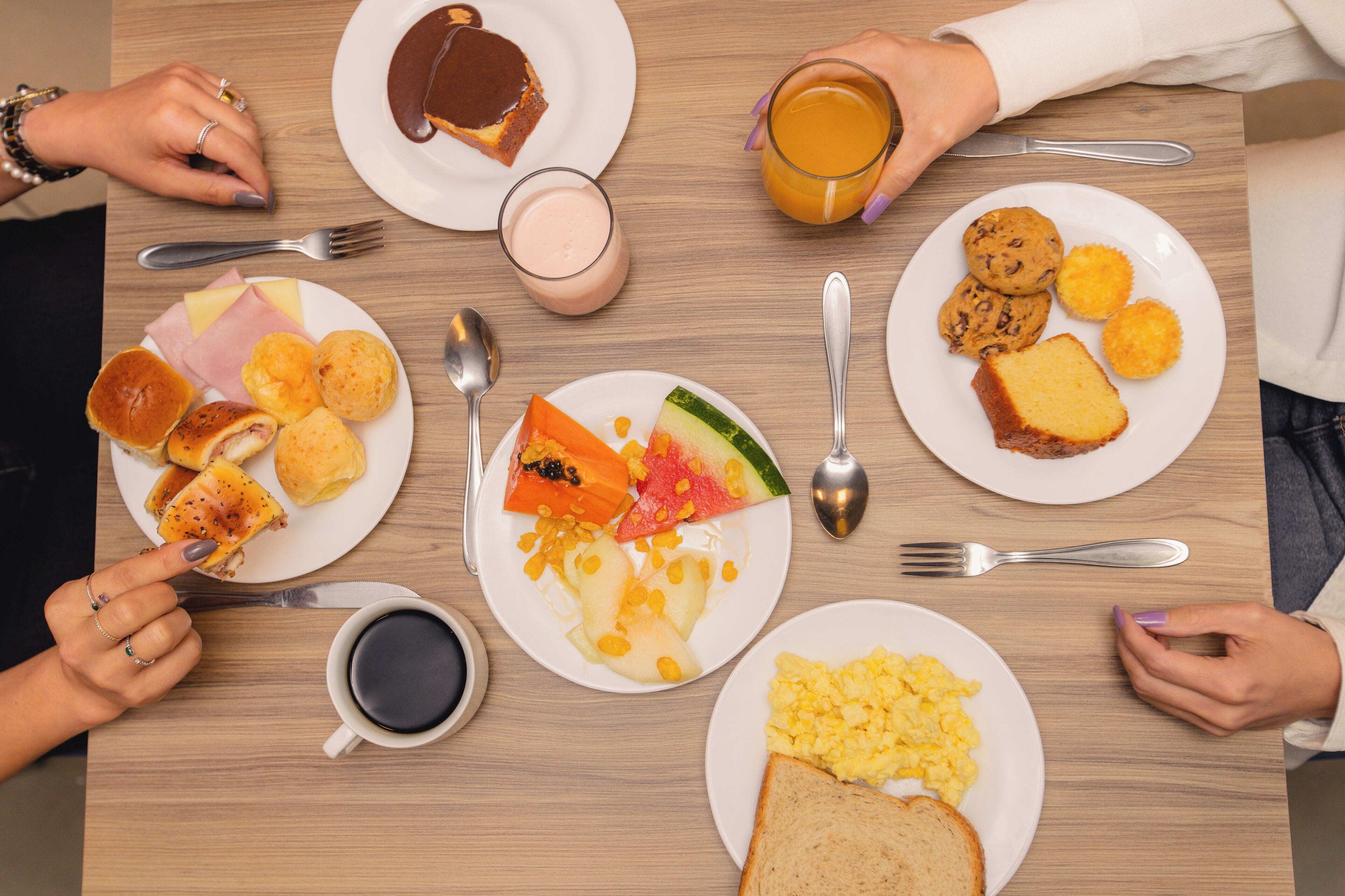 Uma mesa de café da manhã com diversos pratos, incluindo ovos, torradas e frutas.