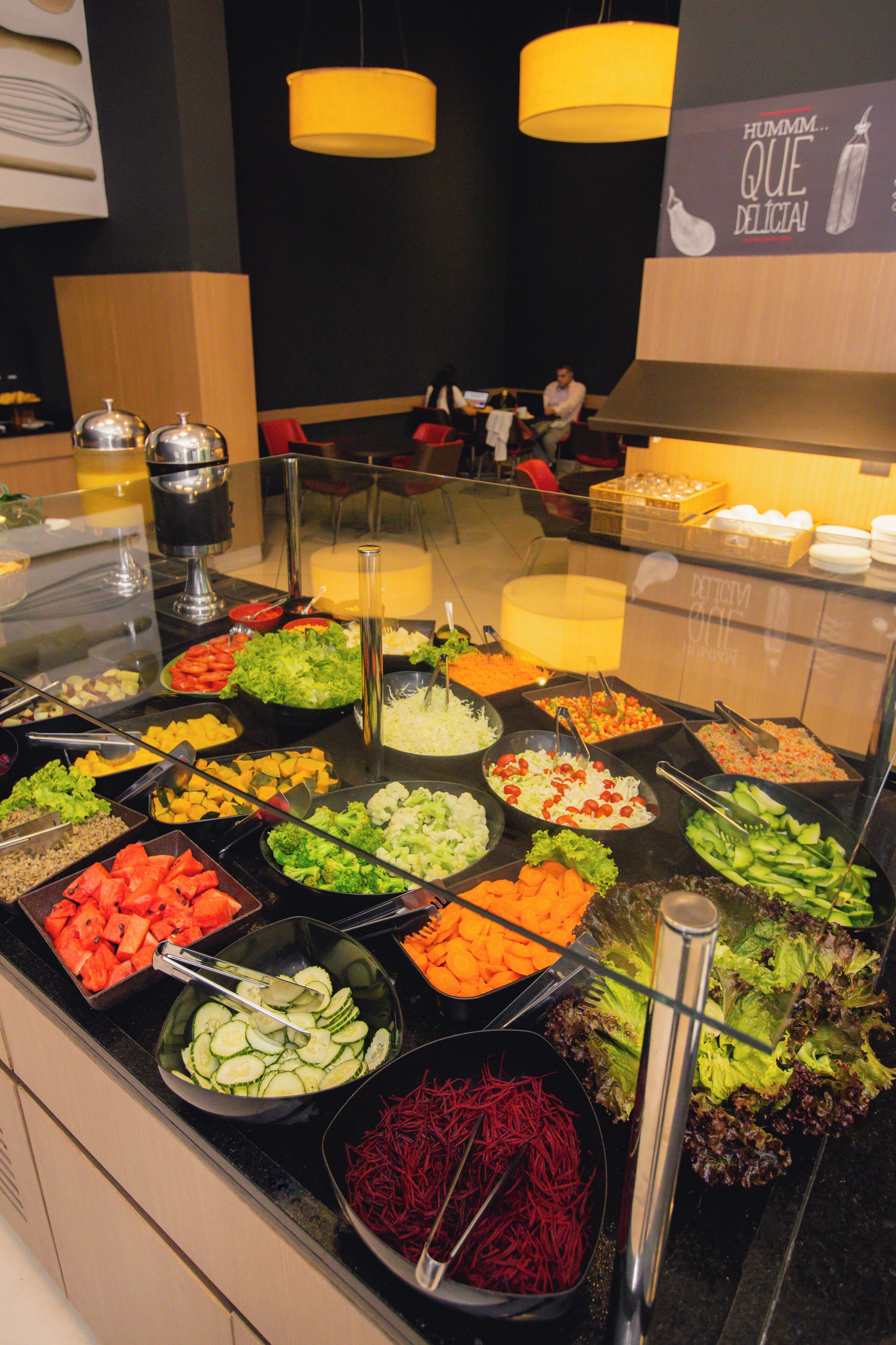 Un bufé con diversas opciones de comida, entre ellas frutas, verduras y ensaladas.