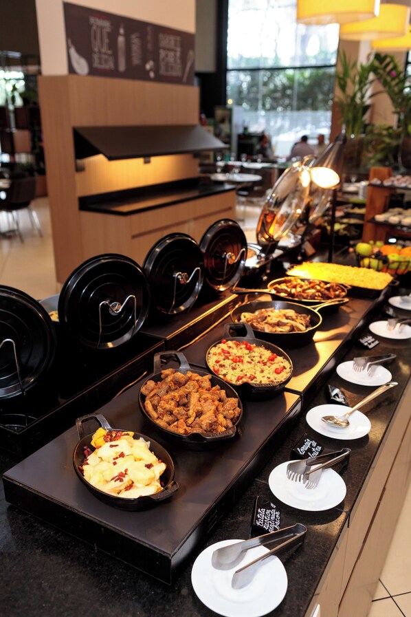 A buffet setup with various dishes and utensils.