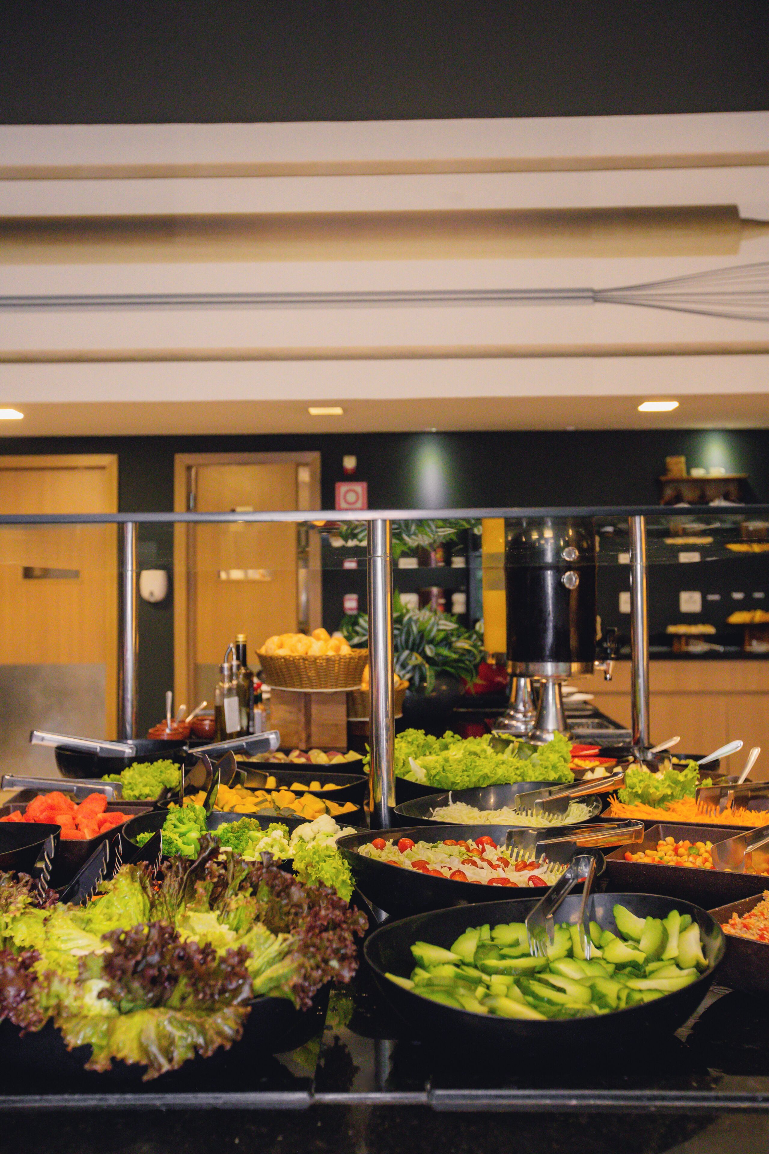 A buffet with various food options including salads, fruits, and vegetables.