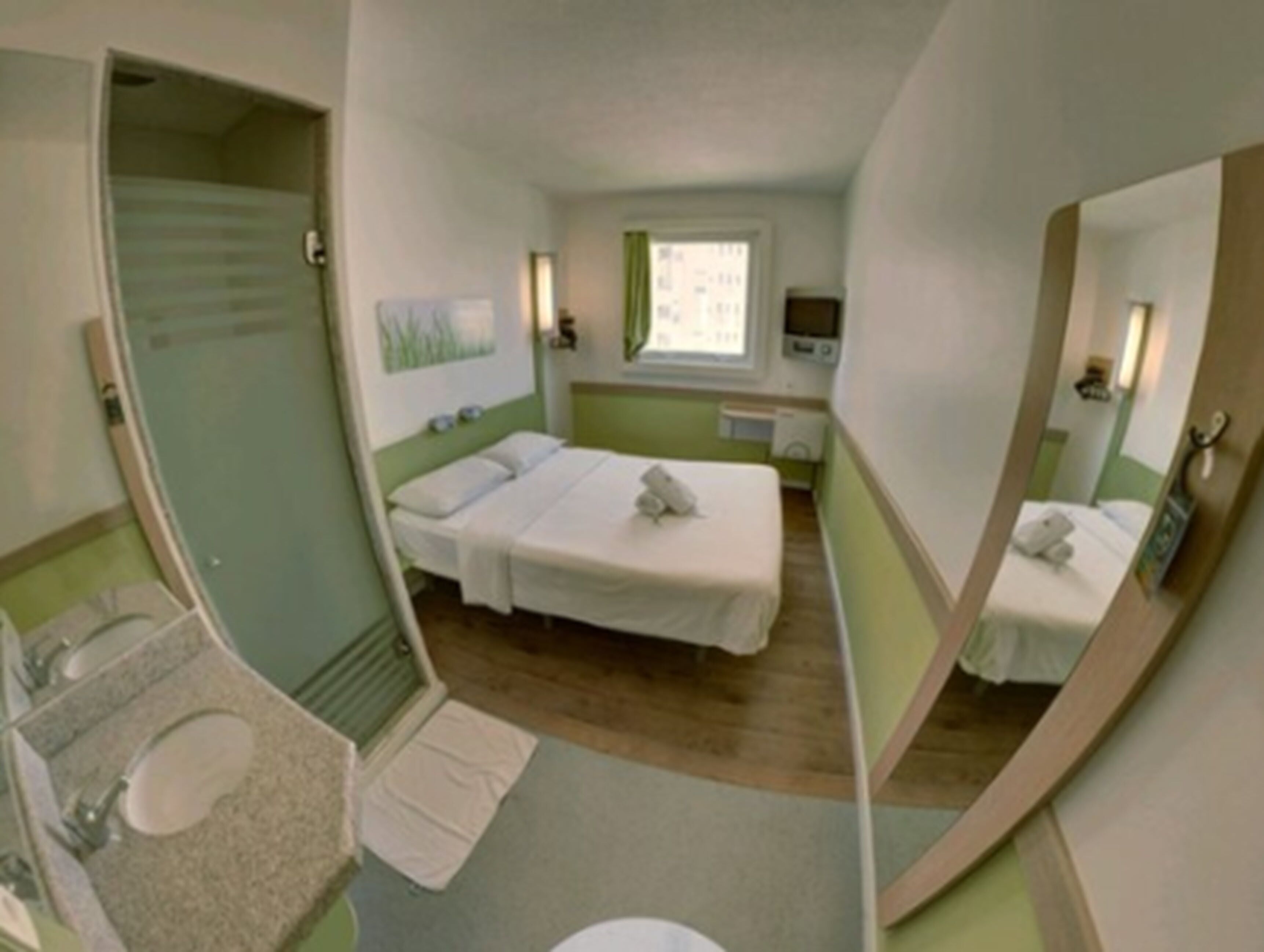 A compact hotel room with two single beds, a small bathroom with a sink and toilet, and a window providing natural light.