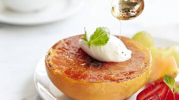 Un dessert présenté dans une assiette, avec une cuillère versant du sirop dessus.