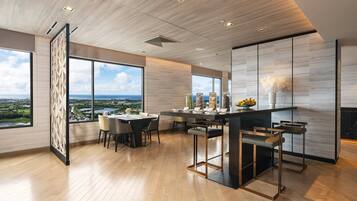 A modern kitchen with a dining area, large windows, and a view of the cityscape.