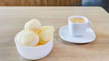 Een witte ijskom en een witte koffiekop op een houten tafel.