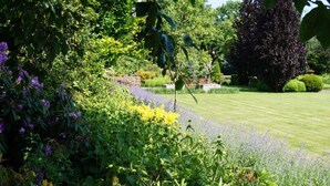 Un jardin bien entretenu, avec une grande variété de plantes et une pelouse soigneusement taillée.