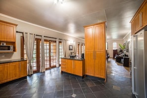 Una cocina amplia con armarios de madera, una isla grande y piso de piedra.