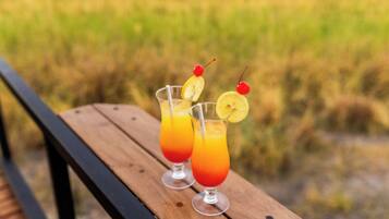 Två glas apelsinjuice med körsbär på ett träbord.