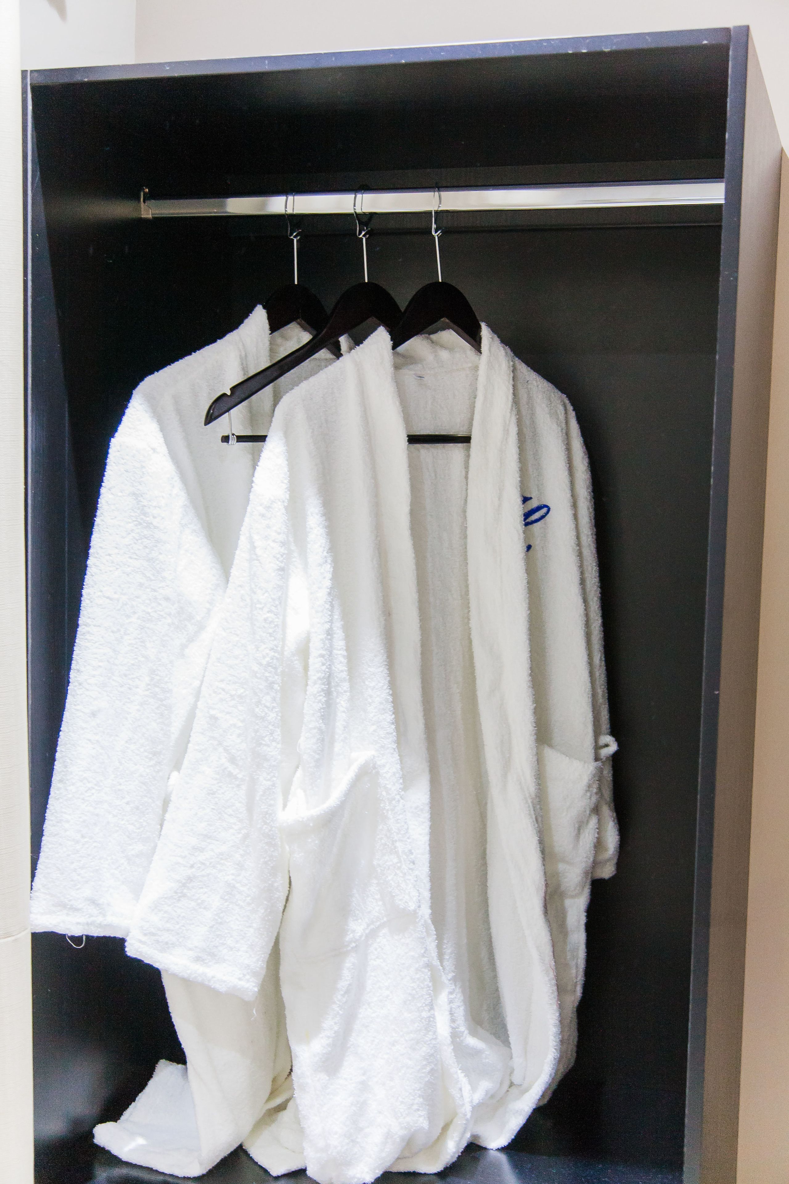 A wardrobe with a hanging rod and a mirror.