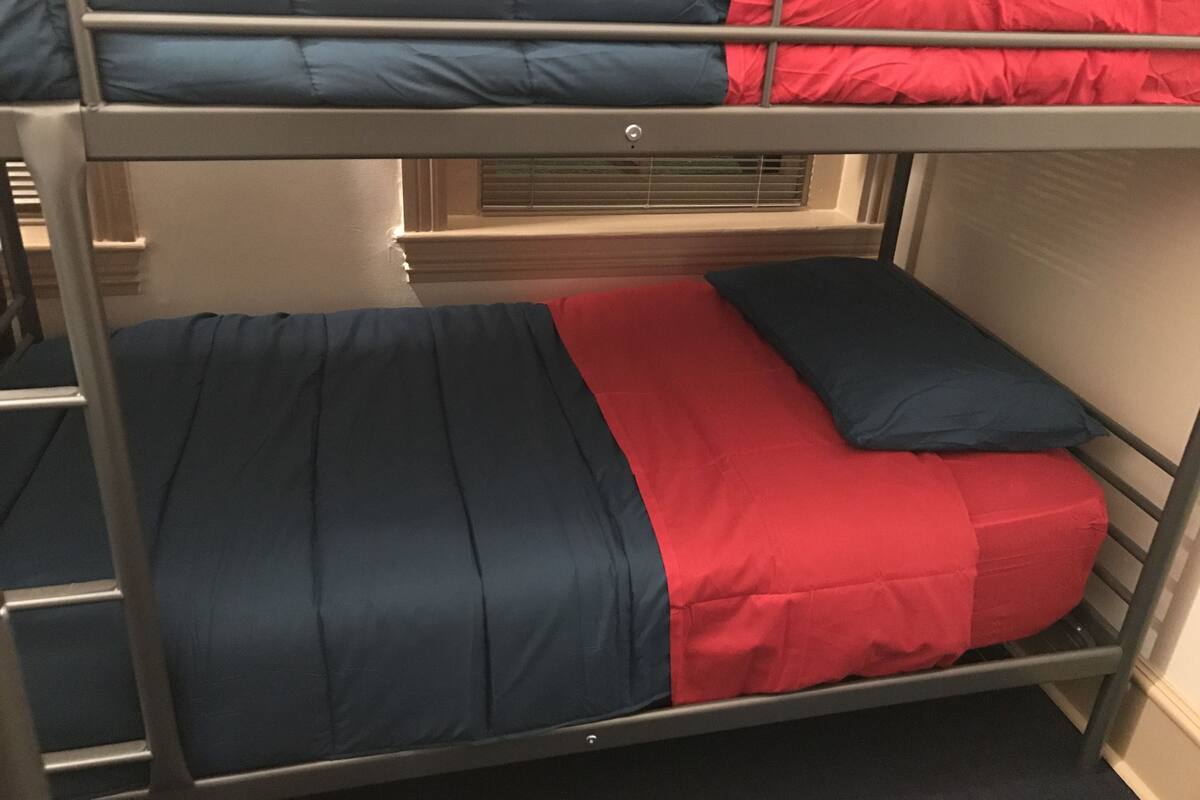 Una cama litera con ropa de cama azul y roja.