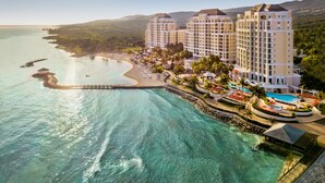 A coastal hotel with multiple high-rise buildings, a beach, and a clear view of the ocean. - Jewel Grande Montego Bay Resort & Spa – All Inclusive (Montego Bay)