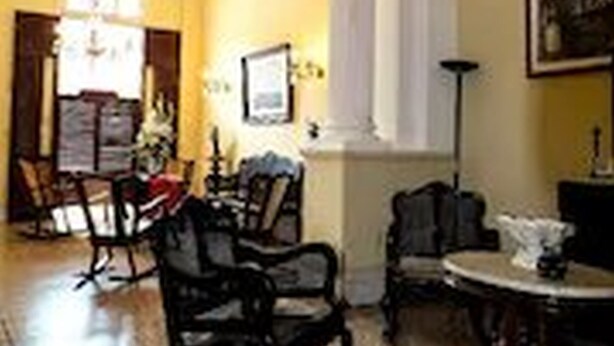 A room with a chandelier, a dining table, and chairs. - Dona Amalia (Cienfuegos)
