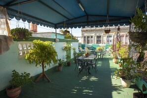 Relax in the serene outdoor patio, surrounded by lush greenery and comfortable seating.