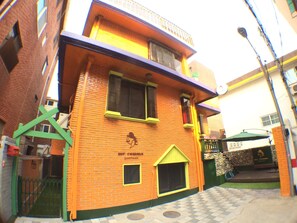 A two-story building with a brick facade and a yellow awning.