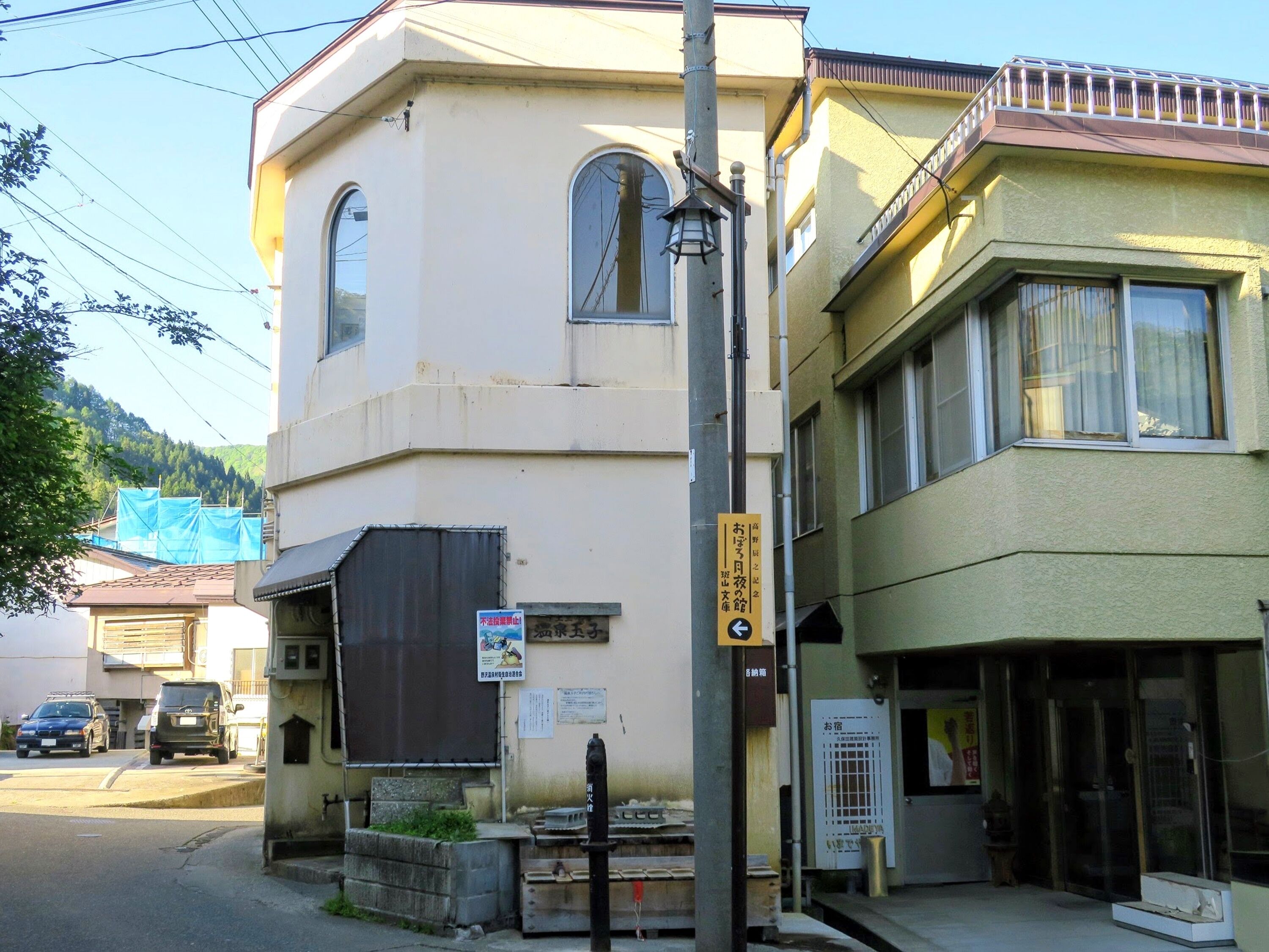 A building with a beige facade, a black awning, and a sign indicating a business.