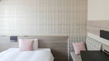 A hotel room with a bed, a sofa, a TV, and a small table.