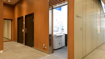 A modern elevator area with wooden paneling and a visible ATM sign.