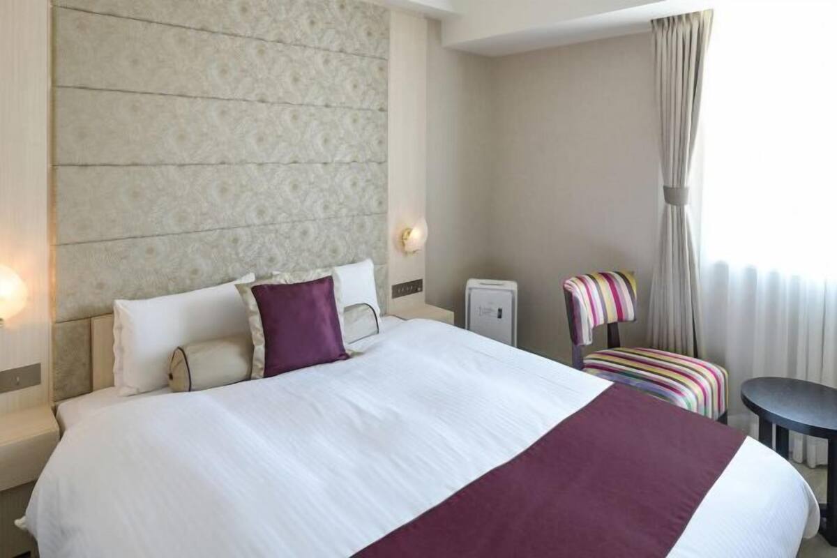 Escritorio, cortinas blackout y tabla de planchar con plancha