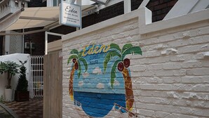Une maison d’hôtes appelée Eden, dont le mur est décoré d’une fresque représentant un palmier.