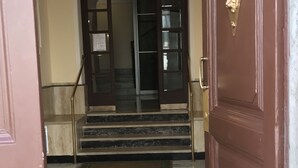 A marble staircase leading to a dark wooden door with a brass handle. - Sweety (Rome)