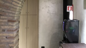 A room with a brick archway, a wooden wardrobe, a black TV stand, and a white ceiling light. - Sweety (Rome)
